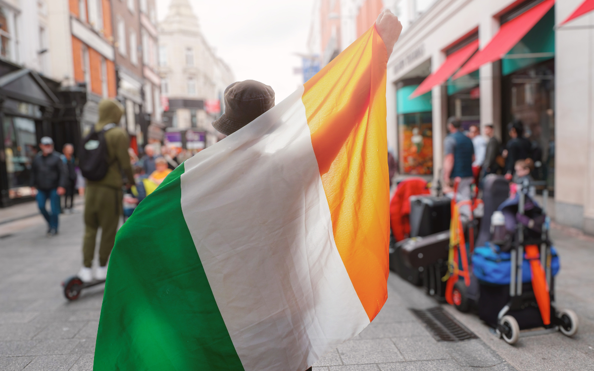 Un irlandais brandissant son drapeau dans la rue. 