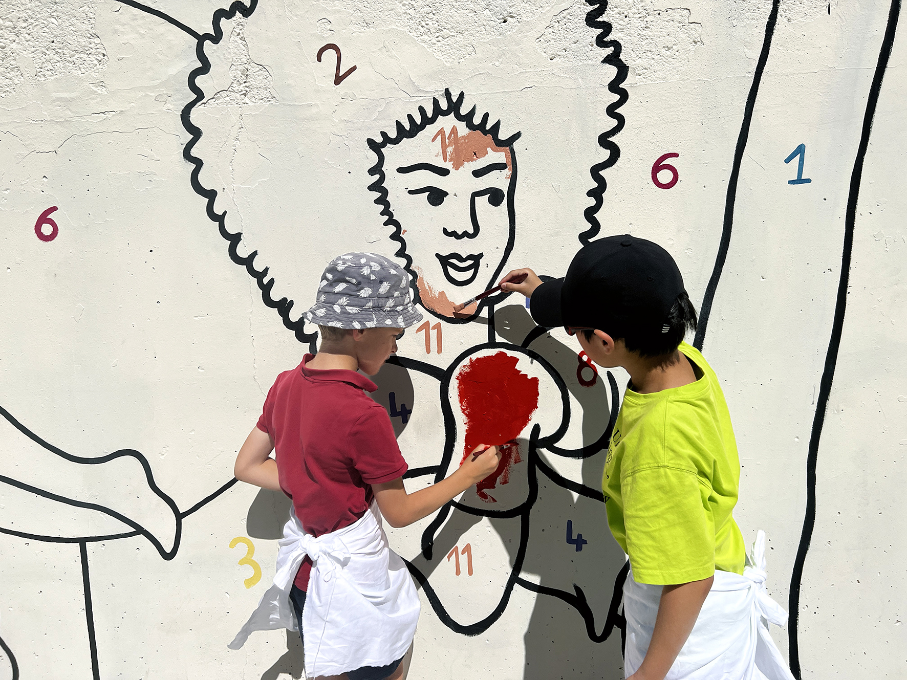 Children contributing to a participative "World flag" fresco with Deborah Di Fiore