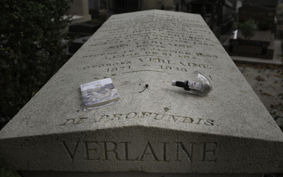 tombe de Verlaine, sur laquelle est posée un livre et une bouteille d'absinthe