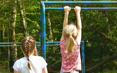 Photo de 2 jeunes filles s'essayant à un module de street workout