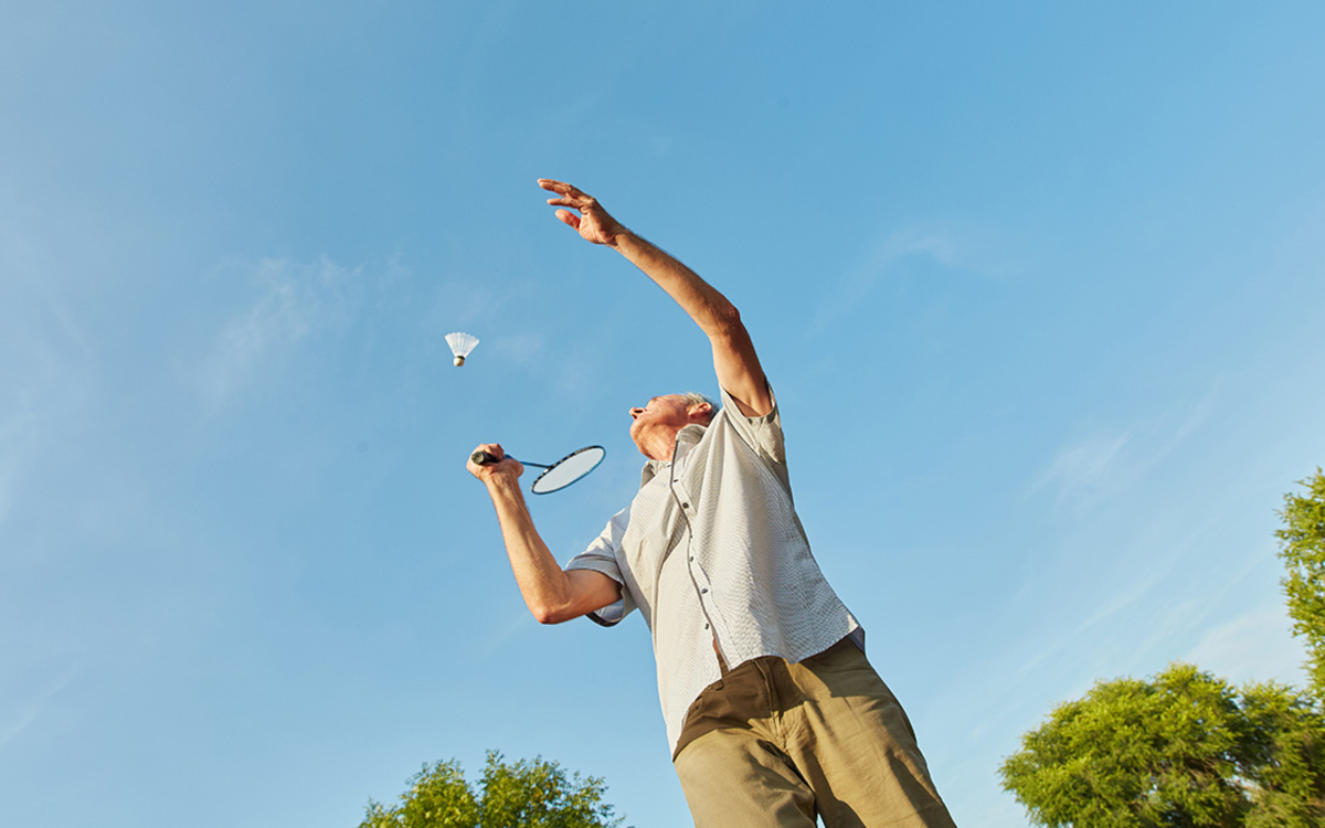 Senior pratiquant du badminton en plein air
