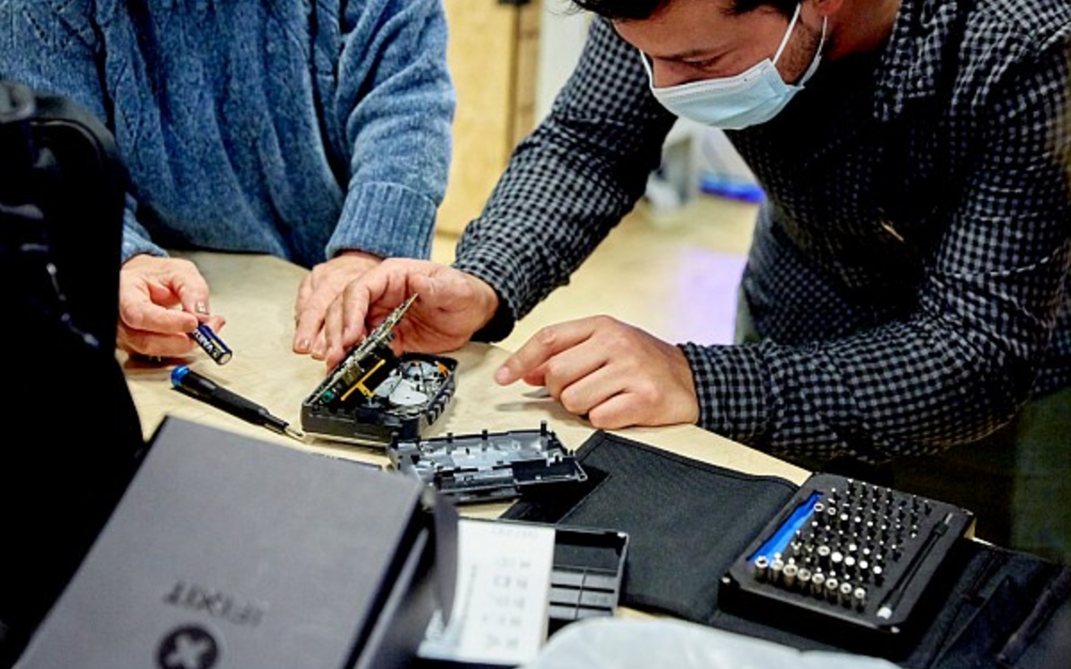 Personnes réparant un téléphone portable.