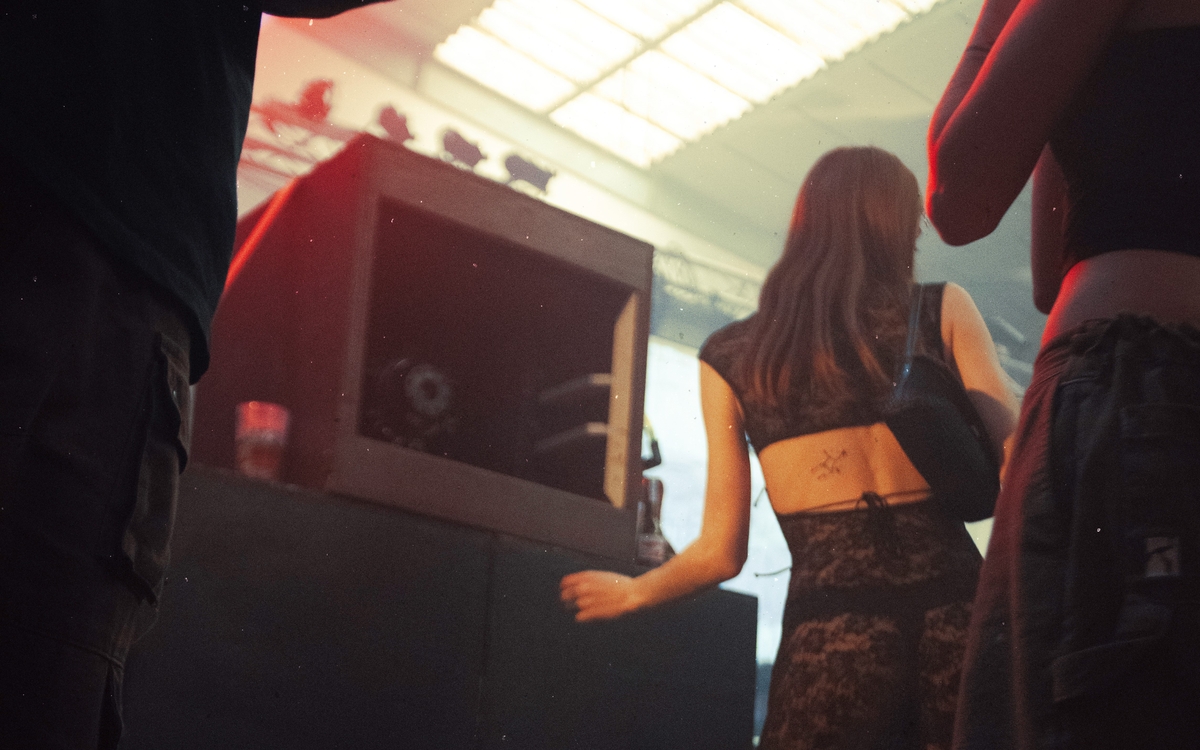 une jeune femme danse face à une large et haute enceinte