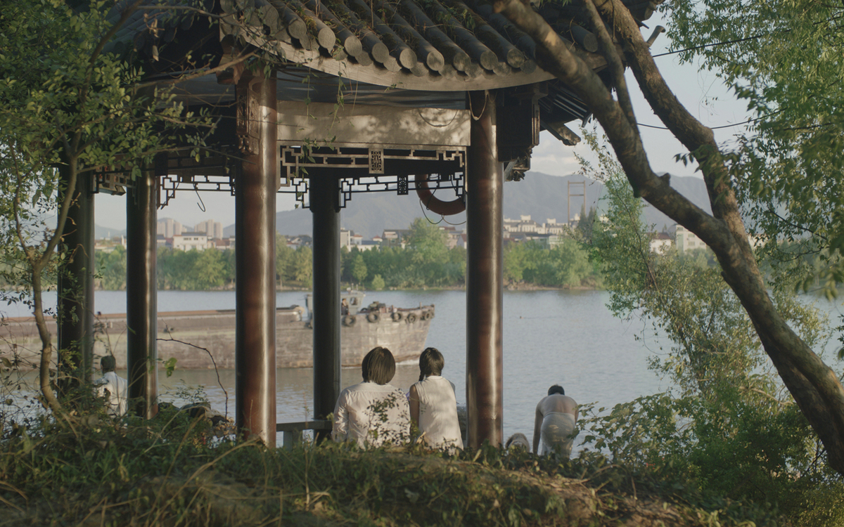 deux personnages du film Séjour dans les monts Fuchun assis devant une étendue d'eau