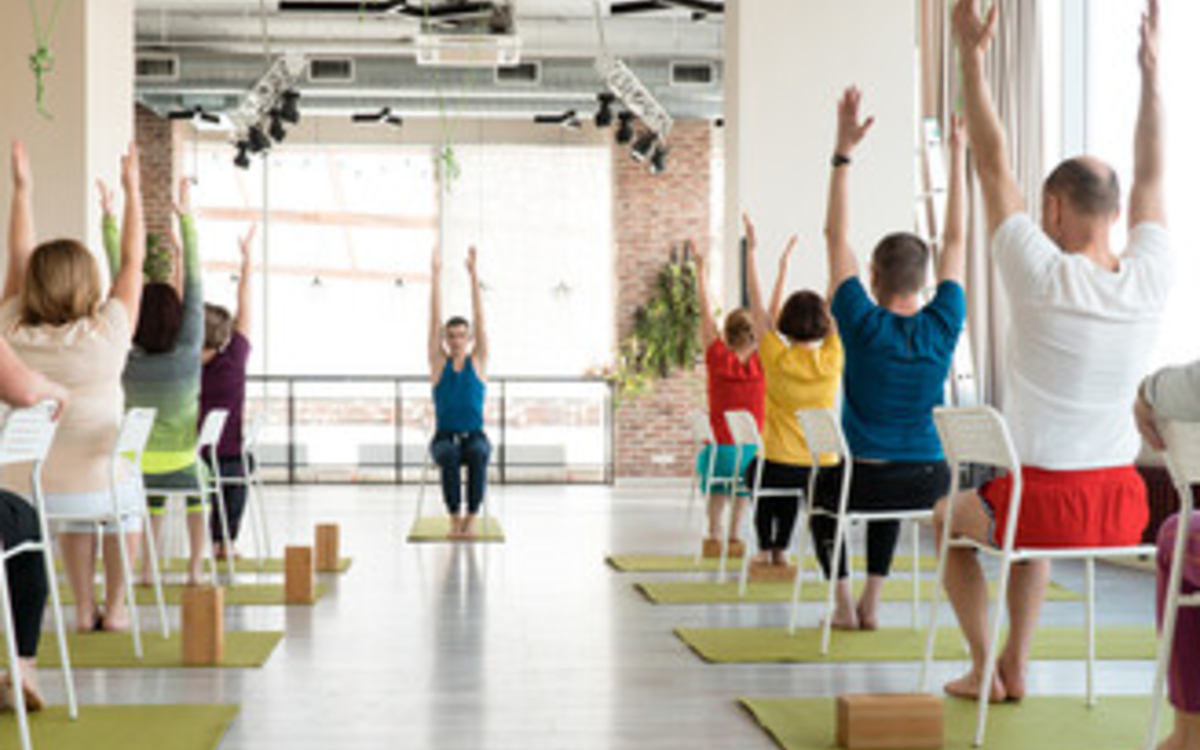 Il s'agit de personnes qui font du yoga assises sur des chaises