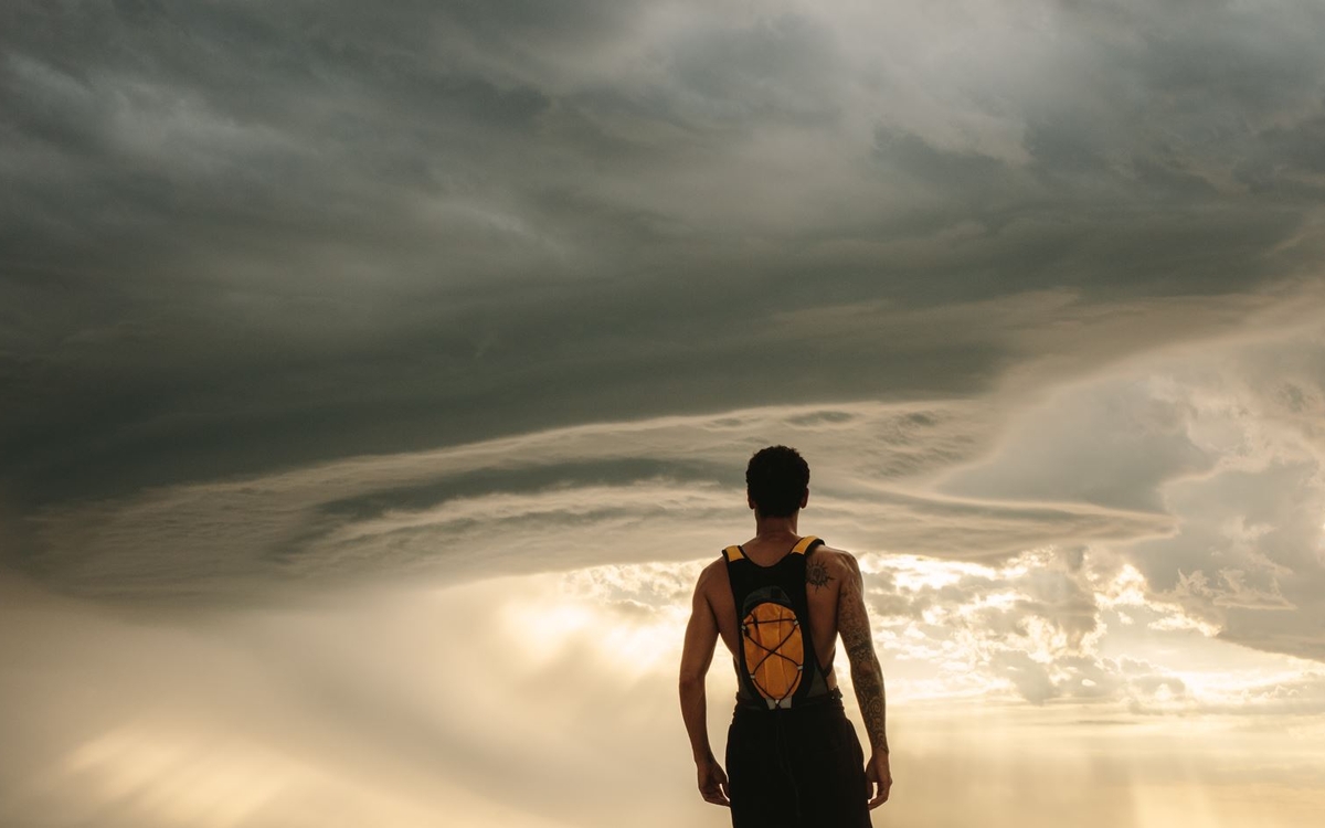jeune sportif face à un ciel d'orage