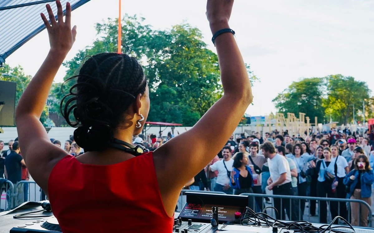 DJ prise de dos devant une foule dans un open air 