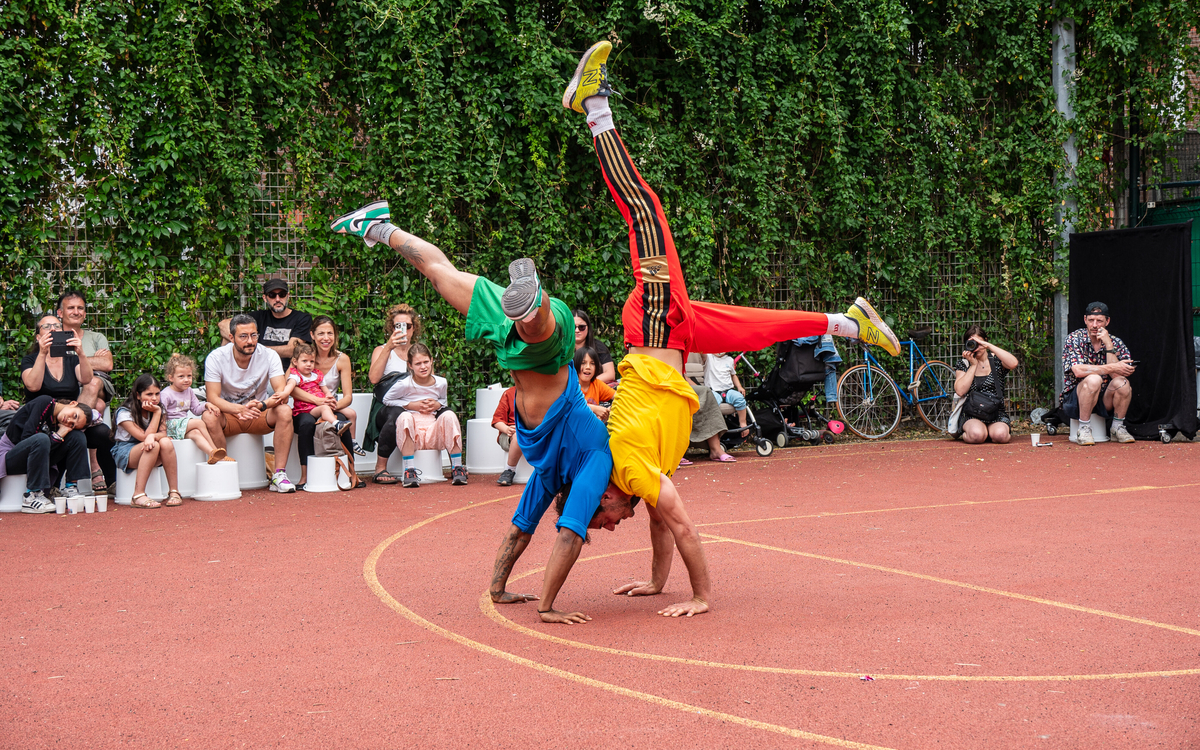 Deux artistes de cirque sont en train de faire un équilibre à deux mains.