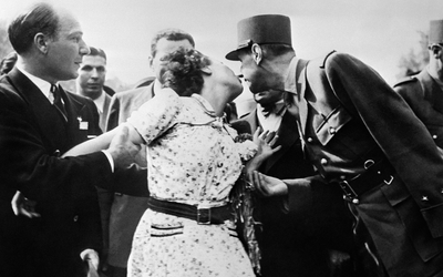 Une Parisienne, l’épouse du cameraman Gaston Madru, manifeste sa joie en embrassant le général de Gaulle lors du défilé du 26 août sur les Champs-Elysées. (Photo AFP)