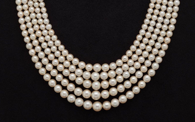 Un collier de perles à cinq rangs exposé dans un écrin de velours noir