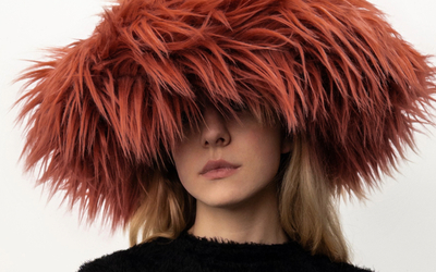 Femme dont les yeux sont cachés par un grand chapeau de fourrure rousse