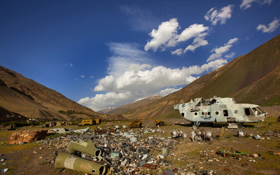 Photo du photographe Reza représentant un paysage aride avec des détritus en premier plan et une carcasse d'hélicoptère 