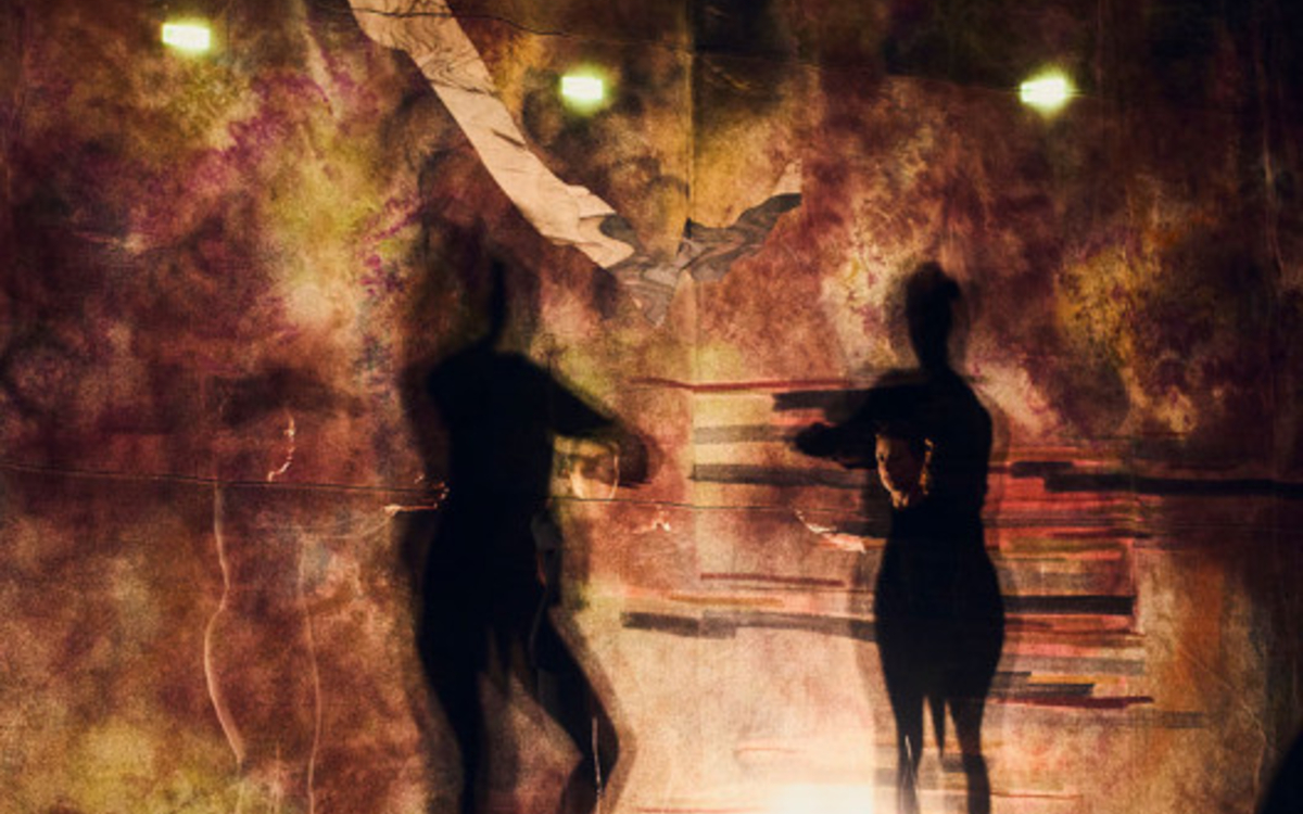 Image floue représentant deux silhouettes ombrées en train de danser