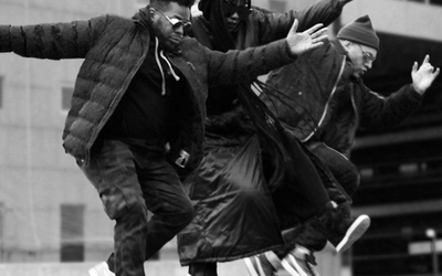 Photo en noir et blanc représentant trois hommes en train de sauter