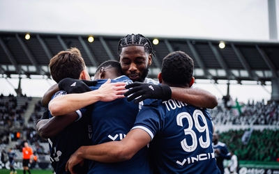 Photo de joueurs de football célébrant un but.