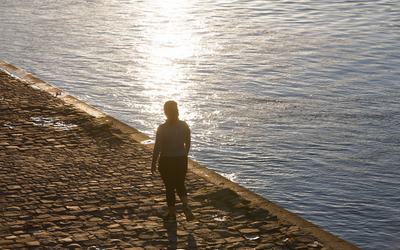 Une personne se promène aux aurores le long de la Seine. 