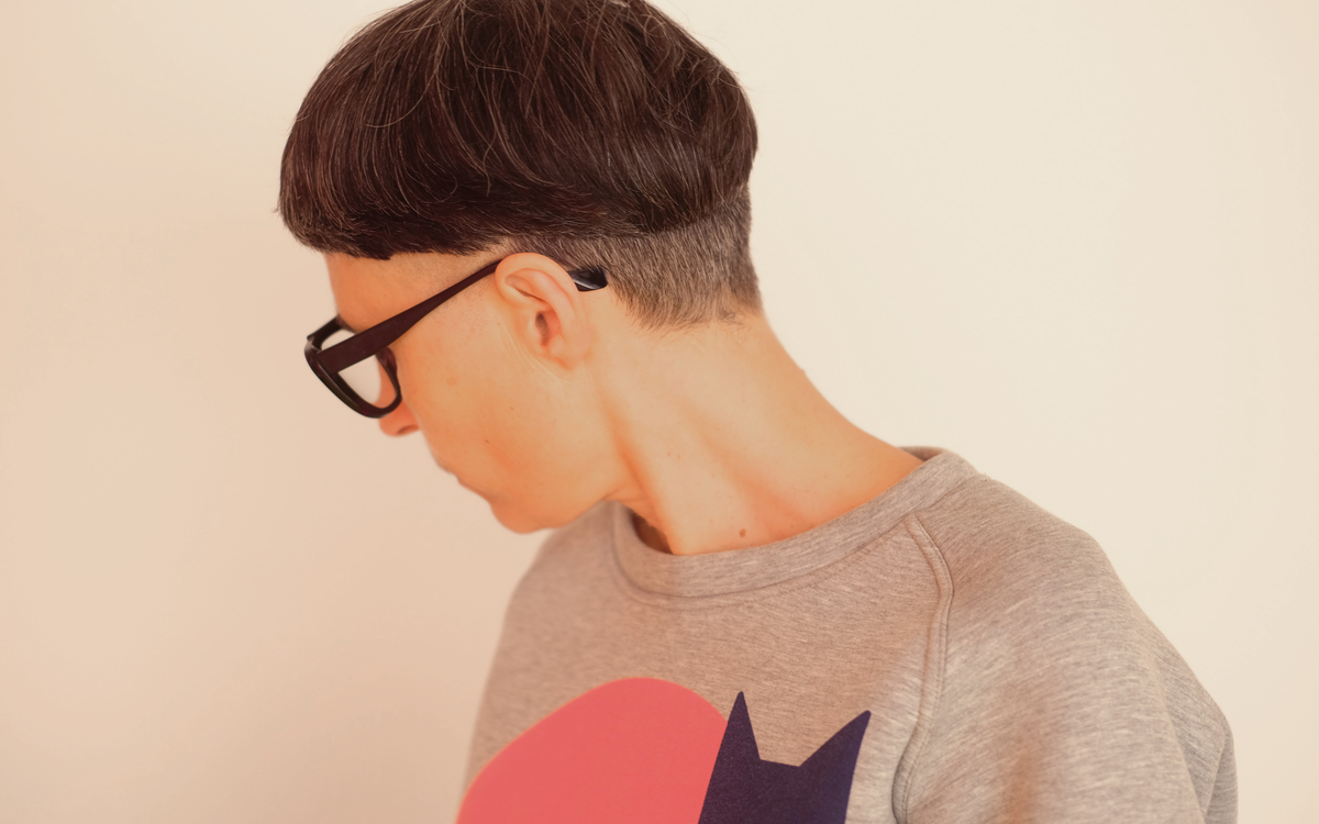 L'image est une photo de matali crasset qui détourne le visage pour regarder derrière elle vers le sol montrant principalement sa coupe de cheveux si particulière