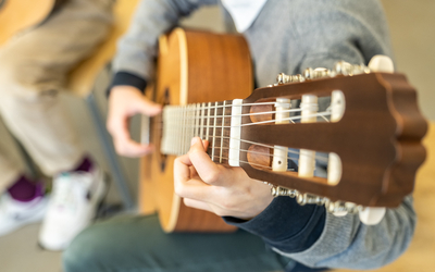Une perosnne jouant de la guitare acoustique.