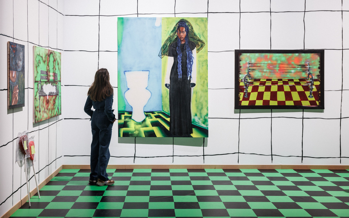 Femme de dos regarde des tableaux colorés accrochés