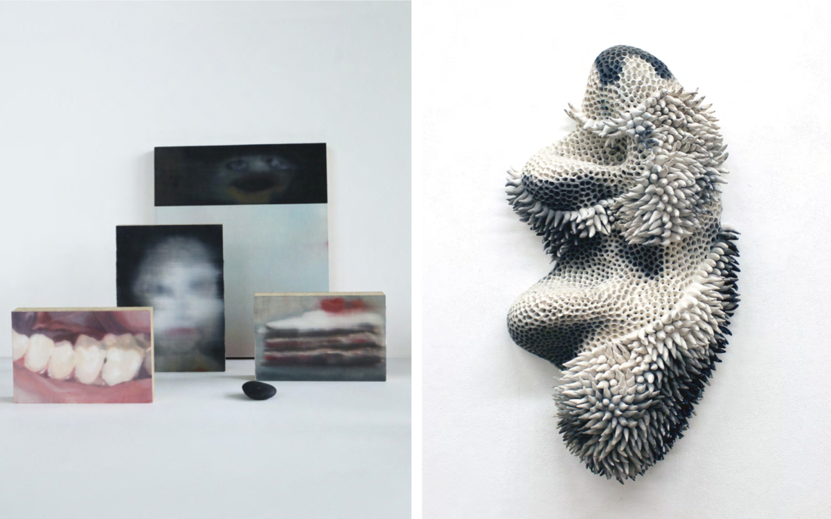À gauche, une série de petites peintures floues posées sur une surface blanche, représentant des images abstraites ou semi-figuratives, comme une bouche avec des dents, un visage et une part de gâteau. À droite, une sculpture murale organique en relief, composée de centaines de pointes en céramique ou en résine, formant une forme abstraite et texturée en noir, blanc et gris.