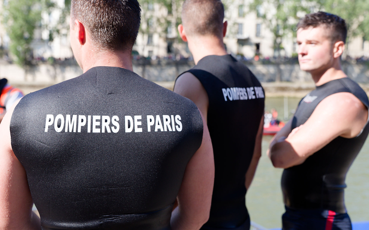 Trois pompiers surveillent la baignade dans la Seine.