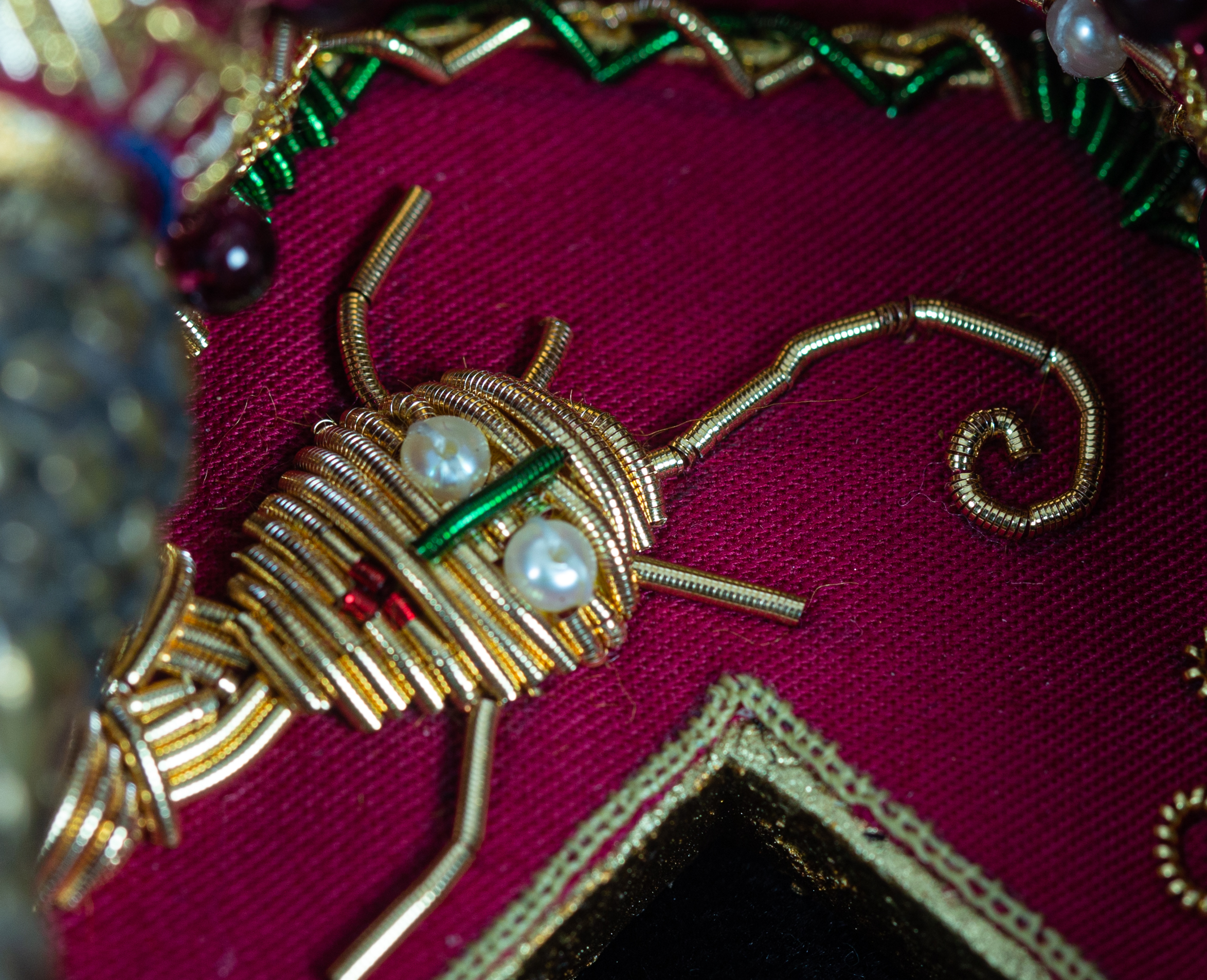 Visage brodé de fils d'or sur un fond pourpre