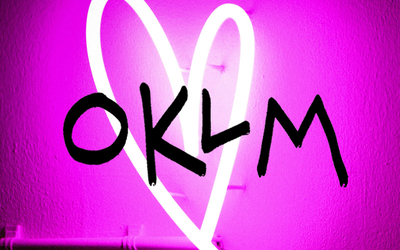 Coeur en néon sur fond rose avec logo oklm