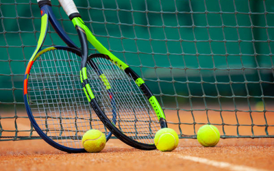 Un court de tennis avec deux raquettes posées contre le filet, avant le début des cours