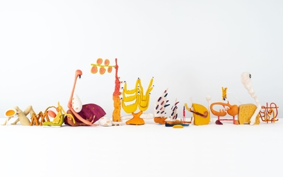 Sur fond blanc, de petites sculptures alignées dans les tons orangés