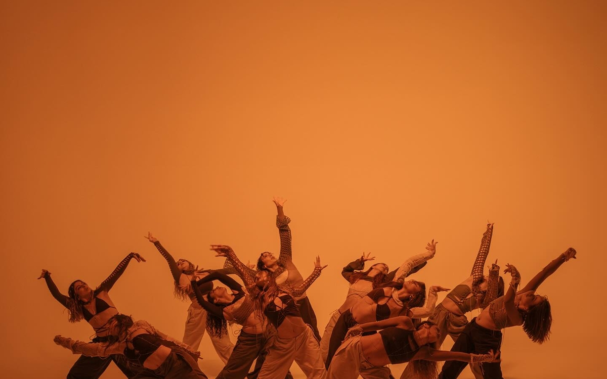 Sur fond orange, des danseurs dansent 