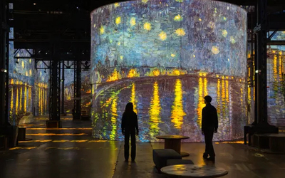 Exposition Van Gogh à l'Atelier des lumières avec des silhouettes devant les oeuvres