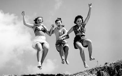 3 jeunes femmes sautent d'une haut d'une dune pour leur plus grande joie. C'est la première fois qu'elles voient la mer