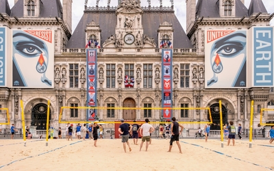 Terrain de volleyball de plage installé devant l'hôtel de Ville. On voit des joueurs sur le sable fin