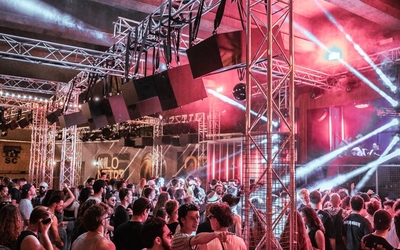 Une foule en train de faire la fête dans un club industriel en plein air