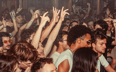 Des gens serrés en train d'agiter les bras et de danser dans un club