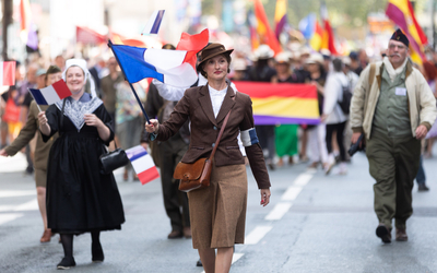 Une femme avec un drapeau défile 