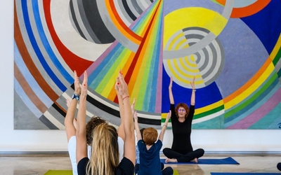 Un cours de yoga devant un grand tableau 
