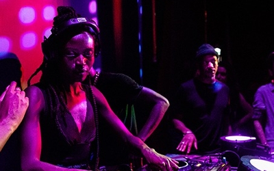 Une femme en train de mixer dans un club