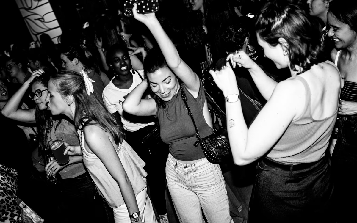 Photo en noir et blanc représentant une foule en train de danser