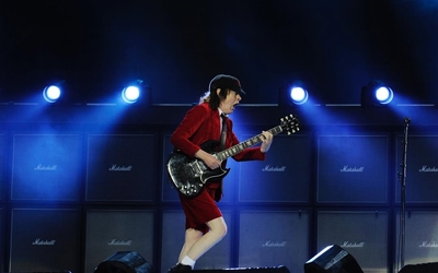 Angus Young, le guitariste d'ACDC, sur la scène habillé d'un ensemble rouge