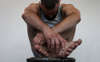 Photographie de Marc Martin représentant un homme blanc et brun replié sur lui-même