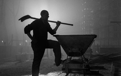 Photographie en noir et blanc de Gaston Paris représentant un ouvrier sur un chantier de nuit