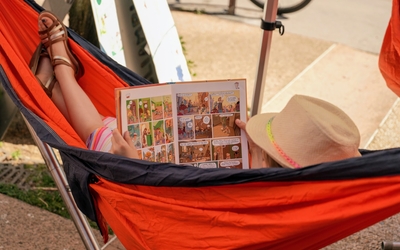 Enfant qui lit dans un hamac