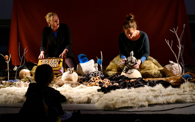 Deux comédiennes assises devant un public d'enfants