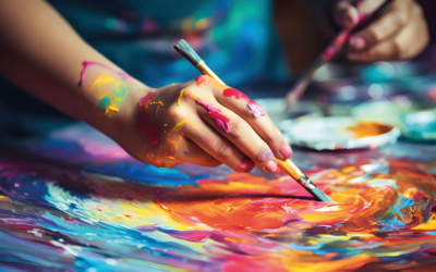 Doigts recouverts de peinture tenant un pinceau 