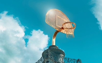 Photo d'un panier de basket doré au soleil.