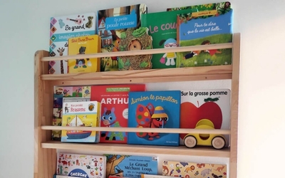 Etagère en bois remplie d'albums pour enfance