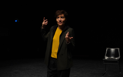 Sur une scène de théâtre, une femme parle 