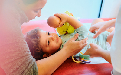 Une mère et son bébé en train de se faire ausculter par une personne d'une PMI. 