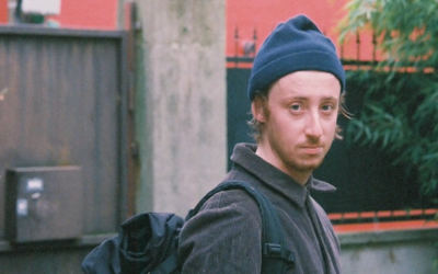 un jeune homme avec un bonnet regarde l'objectif